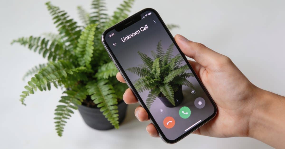 Smartphone en main affichant un appel inconnu