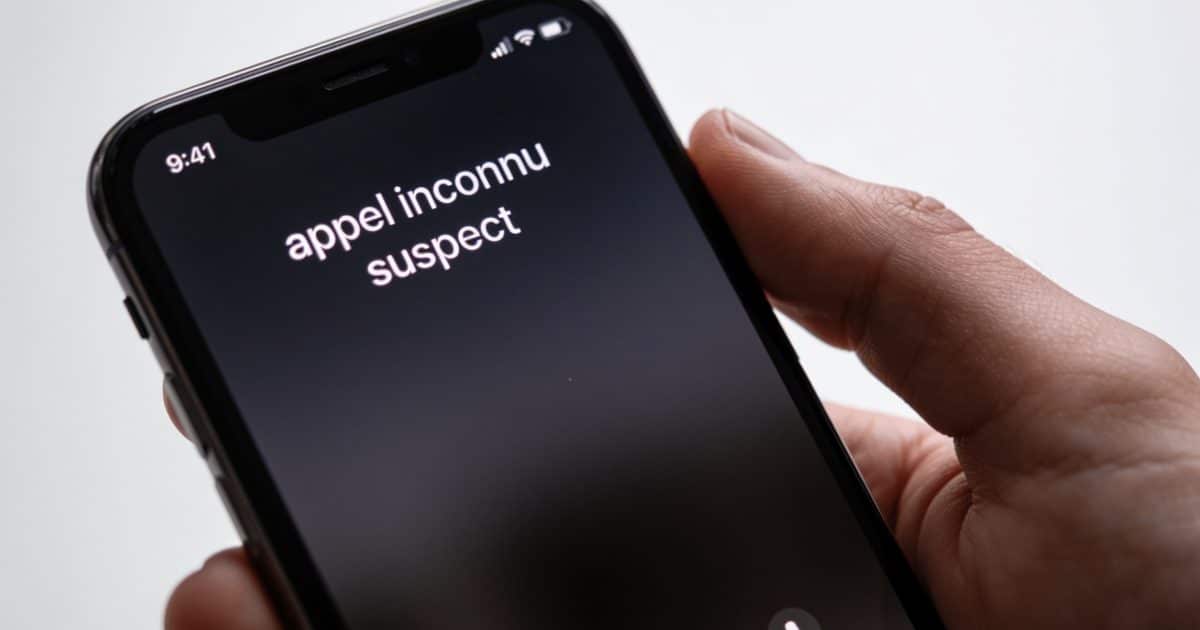 smartphone en main affichant appel inconnu suspect