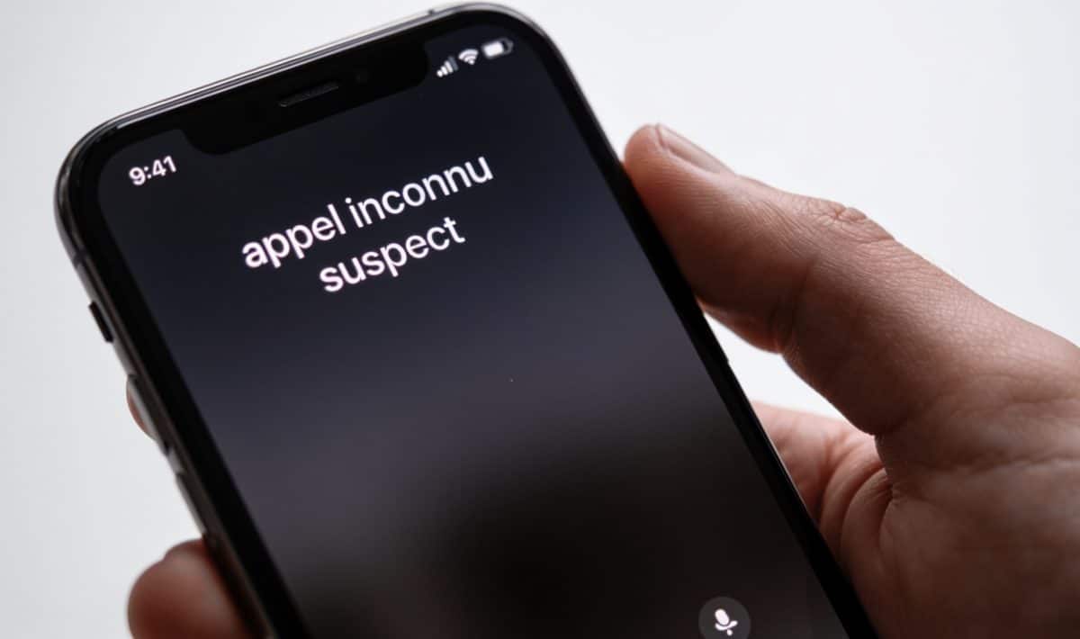 smartphone en main affichant appel inconnu suspect